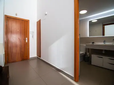 a bathroom with a sink and a wooden door at MD Loft Valterna in Paterna
