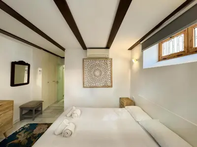 a bedroom with a white bed with towels on it at Duplex en el Carmen 1 in Valencia