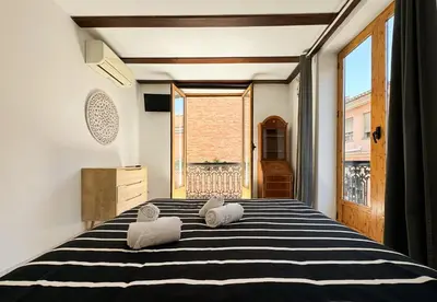 a bedroom with a black and white bed with towels on it at Duplex en el Carmen 2 in Valencia