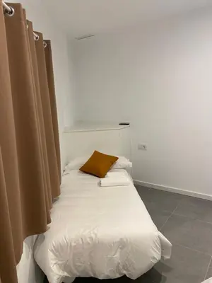 a white bed with a brown pillow on it at Cantalar White in Anna