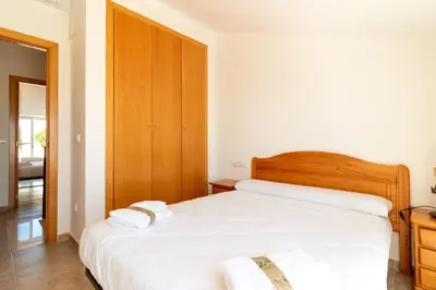 a bedroom with a bed with two towels on it at Global Vacacional, Adosado en primera linea de playa con vistas al mar in Sagunto
