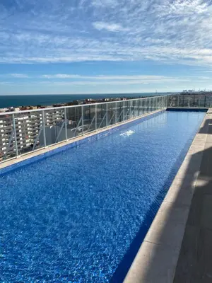 a large swimming pool on the roof of a building at Lowenva beach apartment in Canet de Berenguer