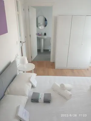 a living room with a white couch and white cabinets at Bonito apartamento con piscina cerca de la playa. in Canet de Berenguer