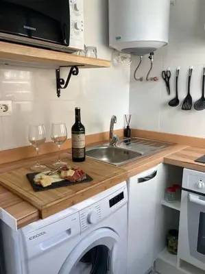 a kitchen with a washing machine and two glasses of wine at Coqueto Apartamento de Playa con Piscina y Terraza in Valencia
