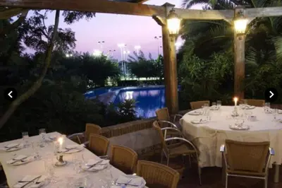 a restaurant with white tables and chairs with lights at Coqueto Apartamento de Playa con Piscina y Terraza in Valencia