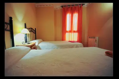 a bedroom with two beds and a window at Apartamentos Rurales San Juan in Castellnovo