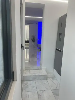 a hallway with white walls and tile floors and a door at DeLuxe House Valencia in Valencia
