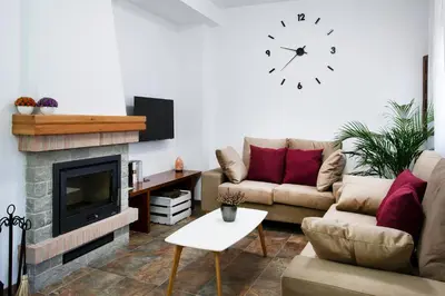 a living room with a couch and a clock on the wall at Torre Buen Aire cerca de Valencia, con jacuzzi y barbacoa in Benafer