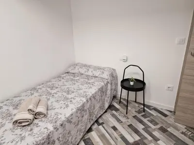 a small bedroom with a bed and a table at Selena Beach in Cullera