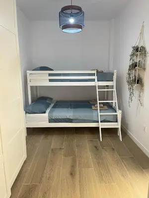 a white bunk bed in a room with a wooden floor at UIM Mediterraneo PB Luis Vives Wifi in Puerto de Sagunto