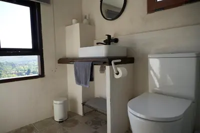 a bathroom with a toilet and a sink and a mirror at Ático El Más allá in Chulilla