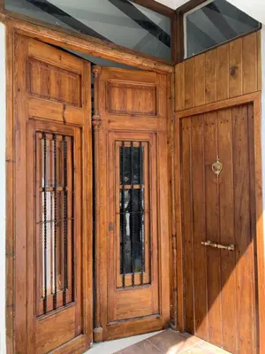 two wooden doors in a room with a ceiling at Ático El Más allá in Chulilla