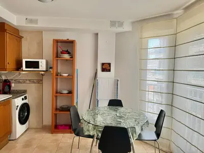 a kitchen with a table and chairs in a room at Acogedor apartamento en el grau de Moncofa con wifi in Moncófar