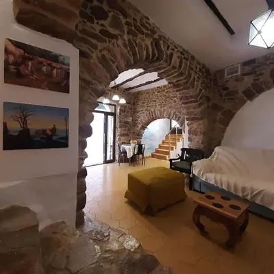 a bedroom with a stone wall with a bed and a table at Casa rural rústica 