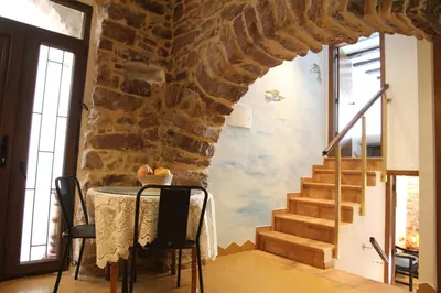a dining room with a table and a stone wall at Casa rural rústica 