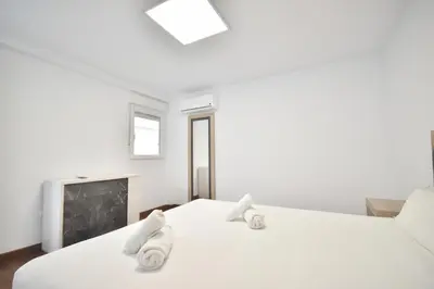 a bedroom with two white beds and a fireplace at Gran piso en barrio historico del centro in Valencia