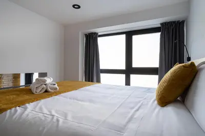 a bedroom with a large white bed with towels on it at Vip Apartments Valencia in Valencia