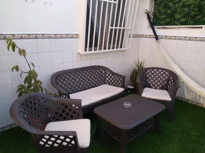 a patio with two chairs and a bench and a table at Casa con encanto y terraza junto a la playa in Valencia