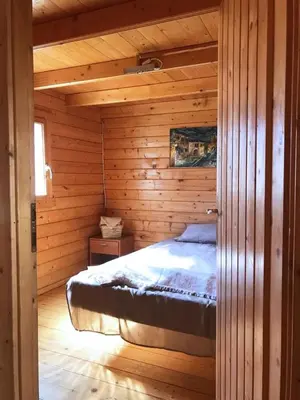 a bedroom with a bed in a wooden cabin at Retiro Siete Aguas in Siete Aguas