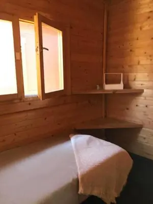 a bath tub in a wooden room with two windows at Retiro Siete Aguas in Siete Aguas