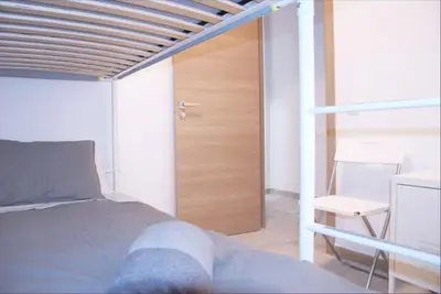 a bedroom with a bed and a wooden door at Vivienda junto a Ruzafa - 12 PAX y más in Valencia