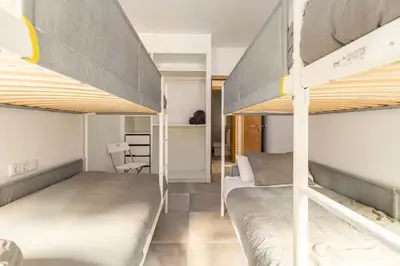 a bedroom with two bunk beds and a desk at Vivienda junto a Ruzafa - 12 PAX y más in Valencia
