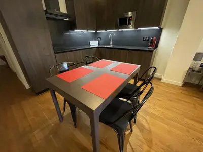 a dining room table with black chairs and a kitchen at Luxury double Suite at heart of Ruzafa in Valencia