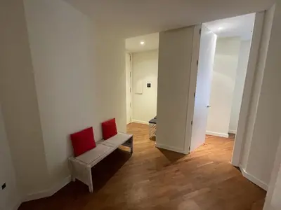 a living room with a bench and a red chair at Luxury double Suite at heart of Ruzafa in Valencia