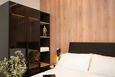 a bedroom with a bed and a black book shelf at Neobeds - Stylish modern 1BR Apt Near Old Town & Steps from Turia Park in Valencia