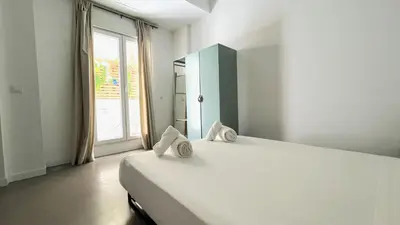 a white bedroom with a large bed and a window at Tarongers, lovely flat in the center in Valencia