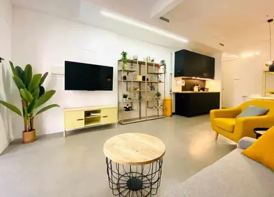 a living room with a yellow couch and a table at Tarongers, lovely flat in the center in Valencia