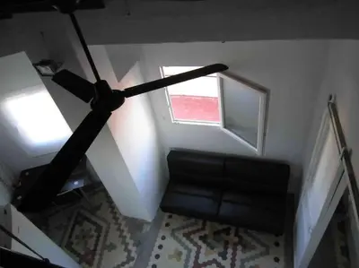 a living room with a black couch and a window at Young Penthouse in Valencia