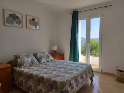 a bedroom with a bed and a sliding glass door at Apartamento rural Casa Calo in Losa del Obispo