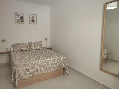 a small bedroom with a bed and a mirror at Apartamento rural Casa Calo in Losa del Obispo