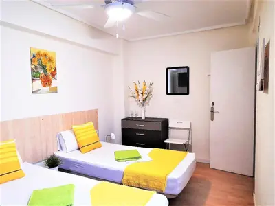 a bedroom with two beds with yellow and white sheets at Double cozy room. Ruzafa - perfect place to stay in Valencia