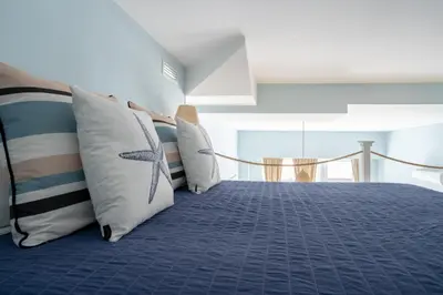 a bedroom with a blue bed with white pillows at Le Méditarranéen de COUP DE COEUR APPARTEMENTS in Valencia