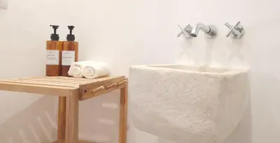 a bathroom with a sink and a wooden table at Casa El Olmo de Navajas in Navajas