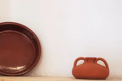 a brown vase sitting next to a plate at Casa El Olmo de Navajas in Navajas
