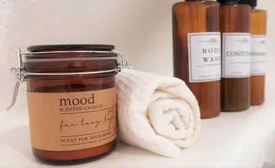 a jar of wood sensitive candle next to a towel at Casa El Olmo de Navajas in Navajas
