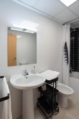 a white bathroom with a sink and a mirror at Magnifico apartamento cerca del centro con A.A. - CID 2 in Burriana