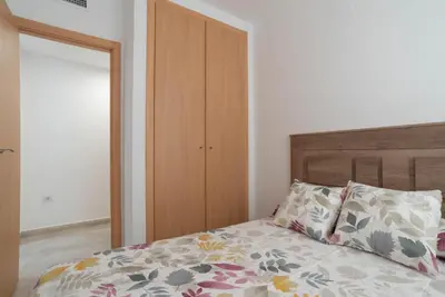 a bedroom with a bed with a wooden headboard at Magnifico apartamento cerca del centro con A.A. - CID 2 in Burriana