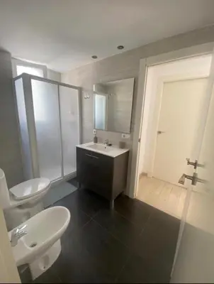a bedroom with a bed and a table and two windows at VALENCIA RENT APARTS MILAGROSA 1 in Valencia