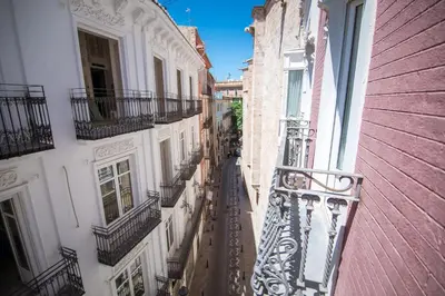 a view of an alley between two buildings with balconies at Petit Palace Plaza de la Reina in Valencia