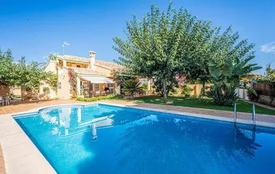a swimming pool in front of a house at Agradable Villa junto al mar con piscina in Sagunto