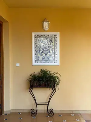 a wall with a picture and a table with plants at Agradable Villa junto al mar con piscina in Sagunto