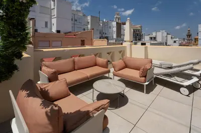 a balcony with couches and a table on a roof at Catalonia Excelsior in Valencia