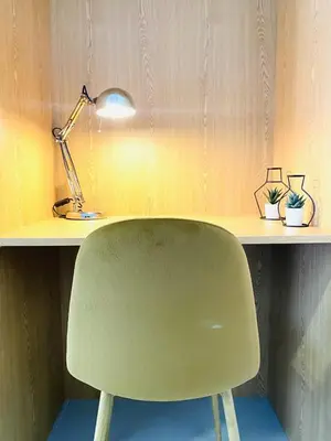 a green chair sitting in front of a desk with a lamp at RUBEN VELA - LOFT CLOSE to RUSSAFA (SOHO) in Valencia