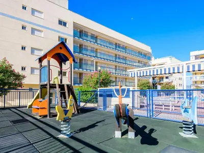 a playground in front of a large building at Apartment Las Dunas by Interhome in Moncófar
