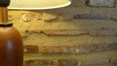 a bottle of liquid next to a brick wall at Ad Hoc Monumental 1881 in Valencia