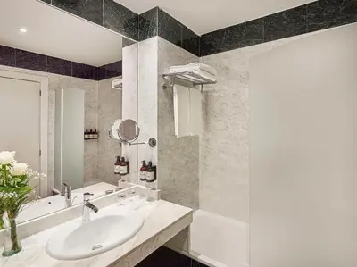 a bathroom with a sink and a bath tub at NH Valencia Las Artes in Valencia